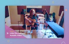 a woman sitting in a chair playing an acoustic guitar