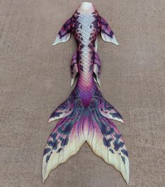 an artistically painted fish tail laying on the ground