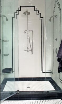 a bathroom with black and white tile flooring, shower stall and glass door to the bathtub