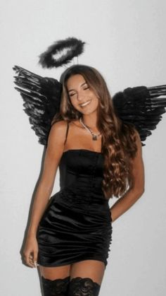 a woman in a black dress with angel wings on her head