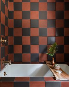 a bath tub sitting next to a wooden tray with a potted plant on it