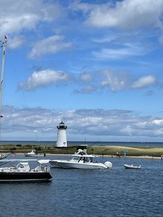 several boats in the water near a light house