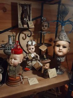 there are many dolls on the table with tags and keys in front of them, including one wearing a hat