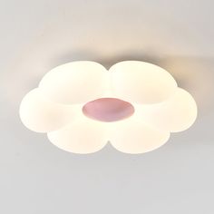 a white ceiling light with three lights on each side and a pink circle in the middle