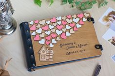 a wedding guest book with hearts on it next to some other personalized photos and cards