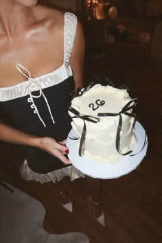 a woman holding a cake with the number twenty two on it