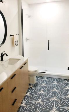 a bathroom with blue and white tile flooring next to a walk - in shower