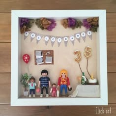 a shadow box is filled with miniature figurines and paper decorations for the family's birthday party