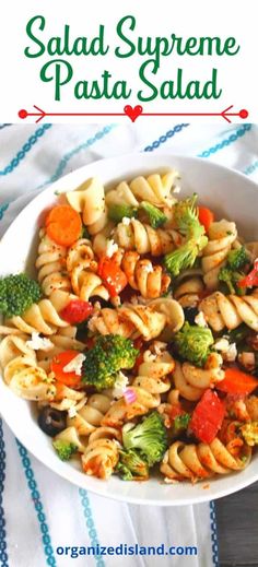 a white bowl filled with pasta salad on top of a blue and white table cloth