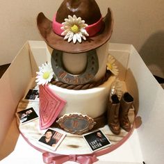 a birthday cake with cowboy hats and pictures on the top is sitting in a box