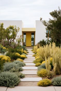 the front entrance to a modern home surrounded by trees and shrubs with yellow doors on either side