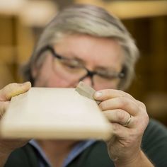 a man holding a piece of paper in front of his face while looking at it