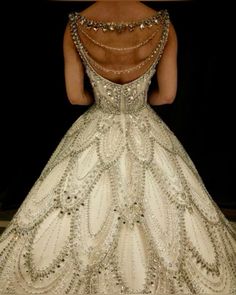 the back of a woman's wedding dress with beading and pearls on it