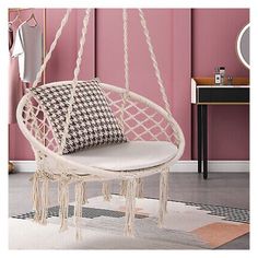 a white hanging chair in a pink room