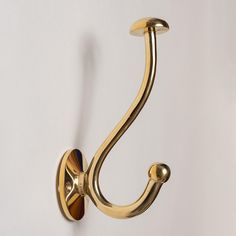 a gold hook on a white wall