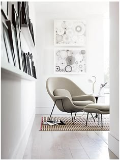 a white room with chairs and pictures on the wall