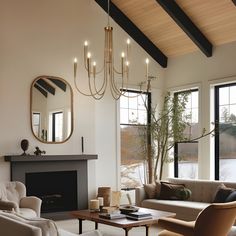 a living room filled with furniture and a fire place under a chandelier next to a window