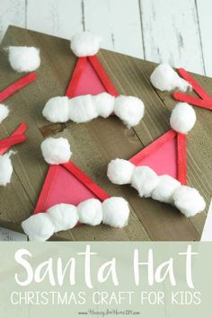 santa hat craft for kids made out of paper and cotton balls on a wooden board