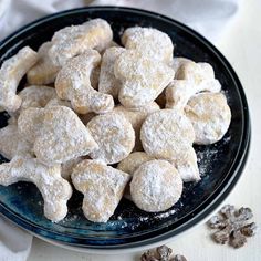 powdered sugar cookies are on a plate next to some dried up snowflakes