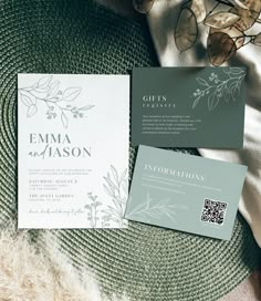 the wedding stationery is laid out on top of a bed with flowers and leaves