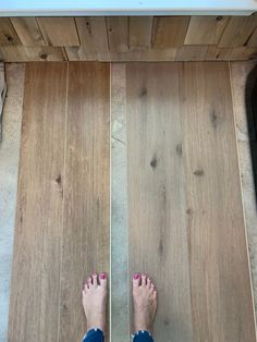 a person standing on top of a wooden floor with their bare feet in the air