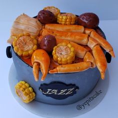 a cake made to look like a pot full of corn, potatoes and carrots