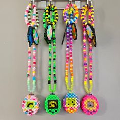 several beaded necklaces are hanging on a wall with numbers and beads attached to them