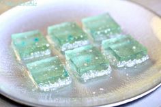 small pieces of green cake sitting on top of a metal plate with powdered sugar