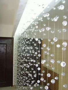 a large glass sculpture hanging from the side of a wall next to a wooden door