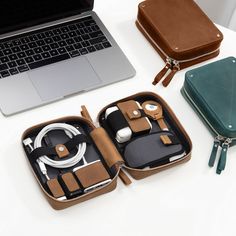 an open case sitting on top of a white table next to a laptop and other items