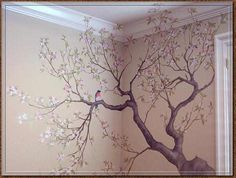 a bird sitting on the branch of a tree painted on a wall in a room