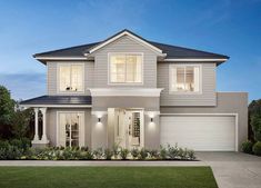 a two story house with white trim and windows at night in front of green grass