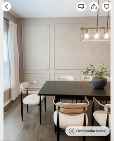 a dining room table with white chairs around it