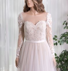 a mannequin wearing a wedding dress with long sleeves