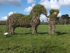 two horses made out of branches in a field