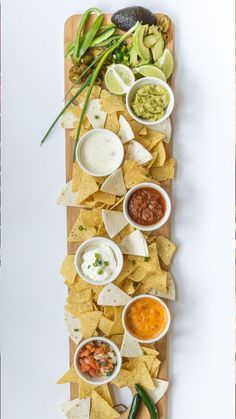 a platter with chips, salsa and guacamole dips on it