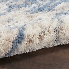 a blue and white rug on top of a wooden floor