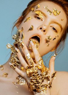 a woman with gold glitter on her face and hands