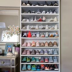 a white shelf filled with lots of baby shoes