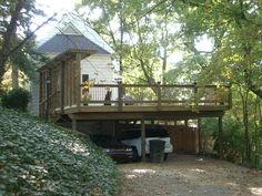 a car is parked in front of a house with a deck on the top floor