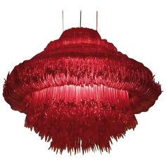 a red chandelier hanging from the ceiling with fringes on it's sides