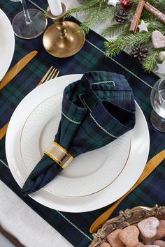 a place setting with plaid napkins and gold trim