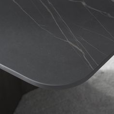 a close up of a black marble table with grey carpet and white walls in the background