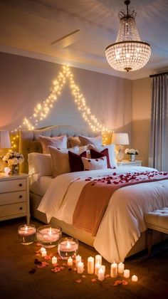 a bedroom with candles on the floor and a chandelier hanging from the ceiling