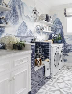 a laundry room with blue and white wallpaper, a washer and dryer