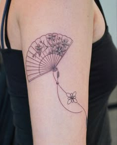 a woman's arm with a tattoo on it and a fan in the shape of a flower