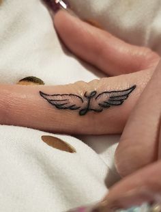 a woman's hand with a small tattoo on it