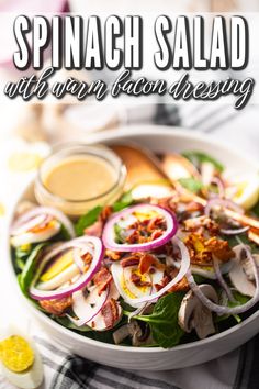 spinach salad with bacon dressing in a white bowl on top of a table cloth