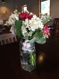 a vase filled with water and flowers on top of a table