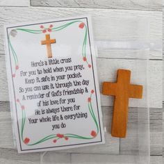 a wooden cross with a card attached to it next to a string that says, here's a little cross for you to hold when you pray